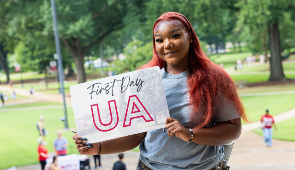 Student holding sign for first day UA